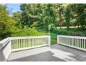 Back deck with wooden deck flooring, white railings, and a view of the backyard at 4292 Hurt Bridge Rd, Cumming, GA 30028