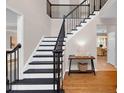 Bright foyer featuring a staircase with black railings, hardwood floors, and a view into the dining area at 3123 Wolf Club Dr. Sw, Atlanta, GA 30349