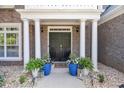 Inviting front door with white columns, potted plants, and lanterns creating a warm and welcoming entrance at 3123 Wolf Club Dr. Sw, Atlanta, GA 30349