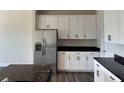 Well-equipped kitchen featuring stainless steel refrigerator and ample cabinet space with dark countertops at 3536 Dogwood Pass, Lithonia, GA 30038