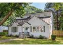 A bright white brick home with dormer windows and a charming blue door, surrounded by a well-kept lawn at 2010 2Nd Ave, Decatur, GA 30032