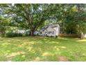 Spacious front lawn leads to a charming white home nestled under a mature tree, offering curb appeal at 2010 2Nd Ave, Decatur, GA 30032
