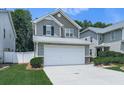Two-story home features gray siding, white garage door, manicured lawn, and neat landscaping at 232 Oconee Way, Canton, GA 30114