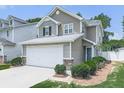 Home with neutral siding, gray accents, two-car garage, and mature landscaping at 232 Oconee Way, Canton, GA 30114