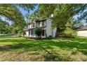 A two-story home surrounded by lush greenery and a well-maintained lawn showing the side of the property at 8649 Cedar Creek Rdg, Riverdale, GA 30274