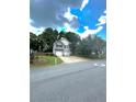 Traditional home with a two-car garage, long driveway and a manicured front yard under a cloudy sky at 227 Bennett Farms Trl, Acworth, GA 30102