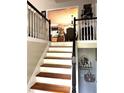 Staircase leading to the second floor, with views of the dining room and decorative elements at 227 Bennett Farms Trl, Acworth, GA 30102