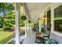 Relaxing front porch with rocking chairs, hanging plants, and a serene view of the surrounding greenery at 207 Lees Lake Rd, Fayetteville, GA 30214