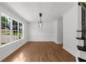 Bright dining room with hardwood floors, large window, and contemporary light fixture at 2688 Beddington Way, Suwanee, GA 30024