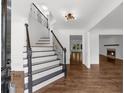 Bright foyer with hardwood floors, a staircase with dark wood railing, and an open view to the living room at 2688 Beddington Way, Suwanee, GA 30024