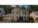 Charming two-story home featuring black shutters, a lush lawn, and well-maintained landscaping at 2688 Beddington Way, Suwanee, GA 30024