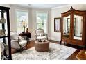 Cozy living room with hardwood floors, vintage armoire, and decorative rug at 4745 Belcrest Way, Cumming, GA 30040