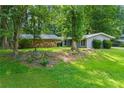 Ranch home featuring natural landscaping, mature shade trees, and a sprawling green lawn at 1328 Hidden Hills Pkwy, Stone Mountain, GA 30088