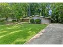 Charming home with a well-maintained lawn and a paved driveway leading to the entrance at 1328 Hidden Hills Pkwy, Stone Mountain, GA 30088