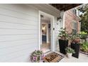 Inviting entryway with potted plants, a 'hello' mat, and a glimpse of the bathroom at 300 Brickworks Ne Cir # 302, Atlanta, GA 30307