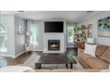 Bright living room showcasing a fireplace, large TV, hardwood floors, and natural light at 9 Saint Claire Ne Ln, Atlanta, GA 30324