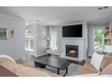 Well-lit living space with fireplace, TV, hardwood flooring, and comfortable seating at 9 Saint Claire Ne Ln, Atlanta, GA 30324
