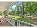 Inviting covered porch with brick flooring and views of the well-manicured front yard at 1406 Arden Sw Dr, Marietta, GA 30008