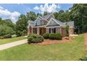 Well maintained brick home with lush lawn, mature trees, and driveway, and a basketball hoop at 501 Highwater Pass, Canton, GA 30114