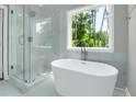 Serene bathroom with soaking tub, glass shower, and large window with tree views at 3439 Twin Village Ct, Snellville, GA 30039