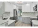Modern kitchen with white cabinets, stainless steel appliances, and tiled backsplash at 3439 Twin Village Ct, Snellville, GA 30039