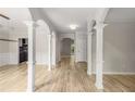 Spacious hallway features hardwood floors, decorative columns, and arched doorways, adding architectural interest at 600 Oakmont Hl, Duluth, GA 30097