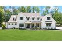 Beautiful modern farmhouse exterior with black windows, covered front porch and lush green lawn at 604 Trinity Church Rd, Canton, GA 30115