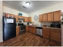 Well-lit kitchen with wooden cabinets, stainless steel appliances, and hardwood flooring at 2390 Coach Way, Jonesboro, GA 30236