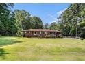 Traditional home boasting a lush, green lawn and mature trees, creating a serene outdoor setting at 2247 Cypress Ave, Morrow, GA 30260