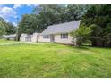 Exterior view of a cozy home with neutral siding, a well-manicured lawn, and a detached garage at 60 Newton Ridge Dr, Covington, GA 30014