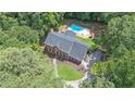Expansive aerial view of a brick home with a private backyard oasis, including a sparkling pool at 10560 Haynes Bridge Rd, Alpharetta, GA 30022