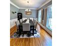 Formal dining room with hardwood floors, wainscoting, and decorative shuttered windows at 10560 Haynes Bridge Rd, Alpharetta, GA 30022