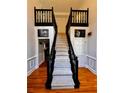 Carpeted staircase features decorative black banister, wood floors and accents at 10560 Haynes Bridge Rd, Alpharetta, GA 30022
