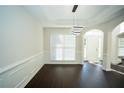Elegant dining room with dark wood floors, wainscoting, and stylish light fixture at 10770 Glenhurst Pass, Duluth, GA 30097
