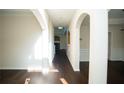 Bright hallway with arched doorways and dark wood floors leading to other rooms at 10770 Glenhurst Pass, Duluth, GA 30097