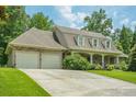 Traditional home showcasing an attached two-car garage and manicured lawn at 2814 Tanner Lake Nw Trl, Marietta, GA 30064