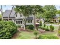 Backyard view of firepit area, lush landscaping and mature trees at 295 Sagamore Nw Cv, Sugar Hill, GA 30518