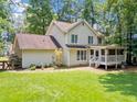 Spacious backyard featuring a lush lawn, screened porch, and mature trees providing ample shade at 5055 Southland Dr, Woodstock, GA 30188