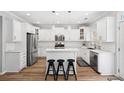 Bright kitchen with white cabinets, stainless steel appliances, and a breakfast bar at 5710 Waters Edge Trl, Roswell, GA 30075