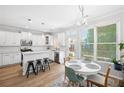 Eat-in kitchen area with stainless appliances, white cabinets, and a modern table set at 5710 Waters Edge Trl, Roswell, GA 30075