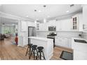 Well-lit kitchen featuring white cabinets, a breakfast bar, and stainless steel appliances at 5710 Waters Edge Trl, Roswell, GA 30075