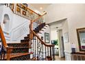Elegant foyer with a wooden staircase featuring an intricate wrought iron railing and stylish decor at 5105 Riverthur Pl, Duluth, GA 30096