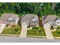 Aerial view of three homes in a suburban neighborhood with mature trees and landscaped yards at 1087 Halletts Peak Pl, Lawrenceville, GA 30044