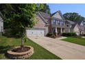 View of a two-story brick home with a two-car garage and well-maintained lawn at 1087 Halletts Peak Pl, Lawrenceville, GA 30044