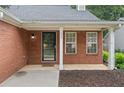 Inviting front porch with brick facade, black door, and two windows at 172 Stoneforest Dr, Woodstock, GA 30189