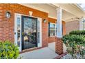Inviting front entry with a black door, brick pillars, and lush green landscaping at 362 Interlake Pass, Mcdonough, GA 30252