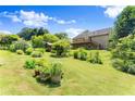 A grassy backyard featuring a deck, shed, mature trees and landscaping at 3260 Governors Court Ct, Duluth, GA 30096
