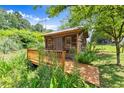 A small, rustic outbuilding with a wood deck and natural landscaping at 3260 Governors Court Ct, Duluth, GA 30096
