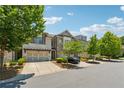 Inviting townhomes line the street with lush trees, manicured landscaping, and two-car garages at 2058 Glenview Park Cir, Duluth, GA 30097