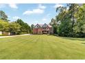 Spacious two-story home with a sprawling front lawn and mature trees at 7125 Heard Rd, Cumming, GA 30041